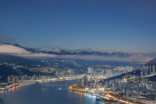 Night cityscape, harbor view, mountain backdrop, urban panorama photo