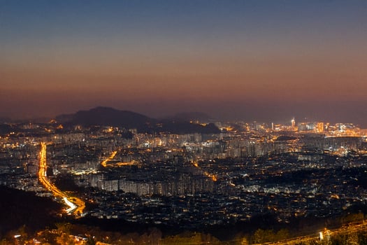Night city panorama, mountain view, twilight glow, urban sprawl, travel poster photo