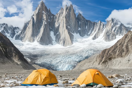 Two tents are set up in front of a mountain photo