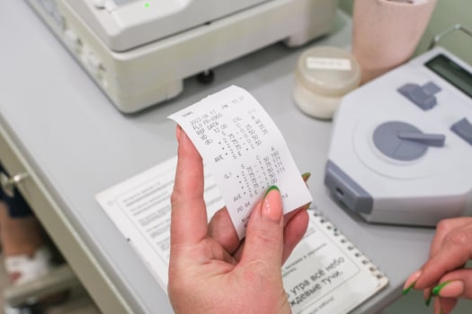 A person holding a piece of paper with a receipt photo