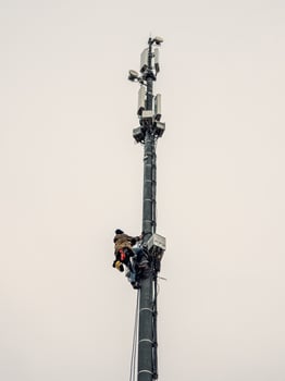 A high rise worker works on a cell tower photo