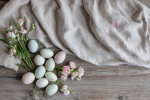 A collection of pale-colored eggs nestled in straw, accompanied by fresh white flowers and soft linen. A serene and organic Easter composition, celebrating spring renewal and rustic elegance photo
