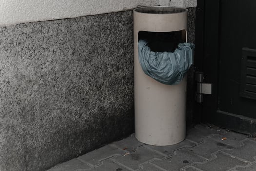 Unusual trash can with a plastic bag in an urban setting during daytime photo