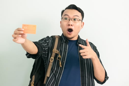 Delighted asian student hold and pointing credit card gesture. Banking, Financial isolated concept. photo