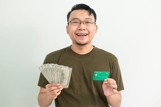 Delighted asian man hold credit card and money. Banking, Financial isolated background, green color concept. photo
