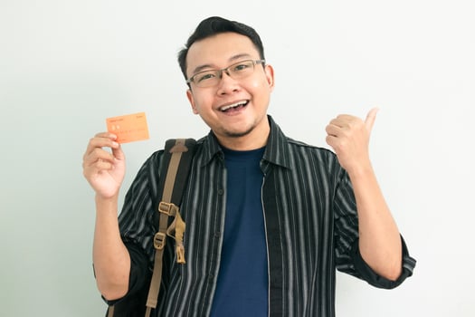 Happy asian student hold credit card with pointing gesture. Banking, Financial isolated concept. photo
