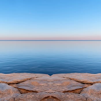 Tranquil ocean view from a rocky shore at sunset photo