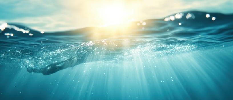 Diving into serene blue water, sunlight filters through waves, creating tranquil atmosphere photo