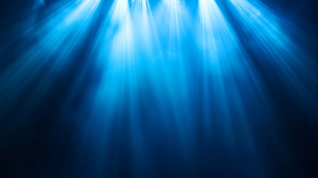Blue beams of light shine through the misty darkness photo