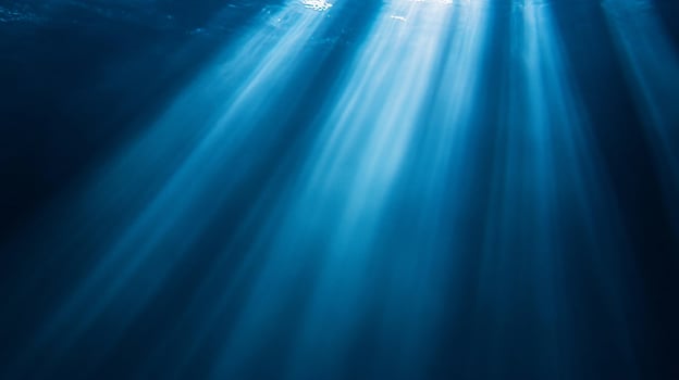 Majestic sunbeams piercing through deep blue waters photo
