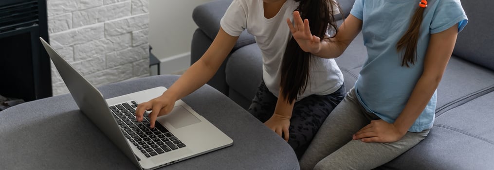 Two girls working on laptop, smiling and older sister help younger photo