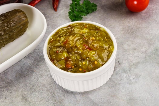 A bowl of pickles and a pickle in a white bowl photo