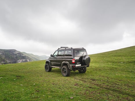 Russia. Dagestan. May 2021 Off-road Uaz patriot vehicle on the edge of a steep cliff. Extreme mountain safari. photo