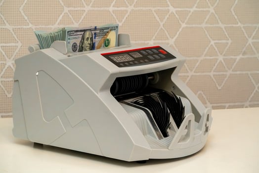 Currency counting machine processing bills in a financial environment photo