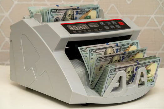 Currency counting machine processing banknotes in a bright setting photo