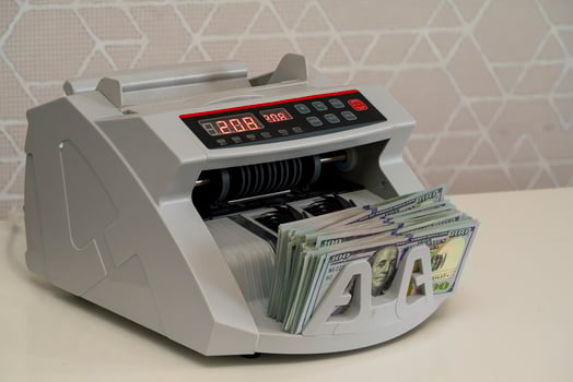 Cash counting machine efficiently processing dollar bills at a bank photo