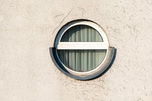 Unique circular window design on a textured wall showcasing modern architecture elements photo