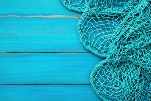 Vintage fishing nets paired with bright buoys on deep turquoise background create a serene nautical theme emphasizing rustic elegance photo