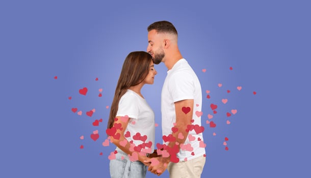 A couple shares a tender kiss, fully immersed in their love for each other, with colorful hearts surrounding them. This moment captures the essence of celebration and affection. photo