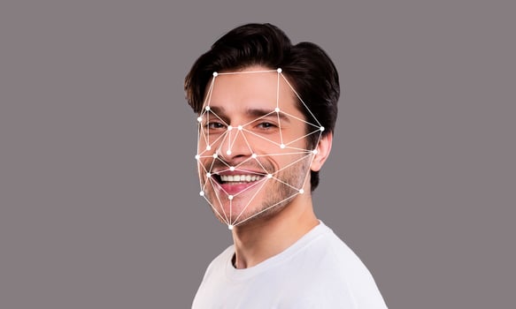 A man displays a joyful expression while facial recognition technology analyzes his features. The background is neutral, emphasizing the technological aspect of identification systems. photo