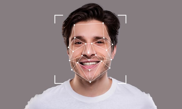 A young man is smiling while being analyzed by facial recognition technology. The geometric overlay highlights key facial features, illustrating advanced identification capabilities. photo