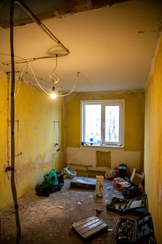 Small Room Under Renovation with Yellow Walls and Exposed Wiring photo
