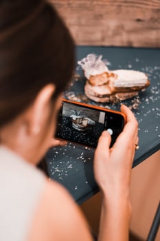 Person Capturing a Powdered Pastry on a Dark Blue Table photo