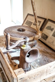 Vintage Hand Operated Grain Mill in Museum Exhibit Setting photo