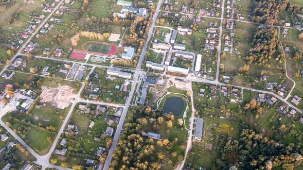 Aerial View of Small Town with Pond, Sports Complex, and Forests photo