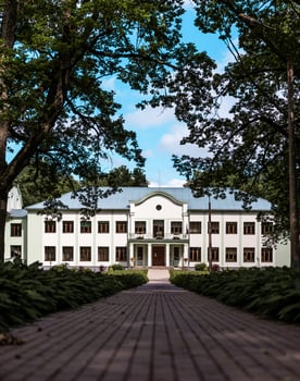 Symmetrical Two Story Building with Green Facade and Central Balcony photo