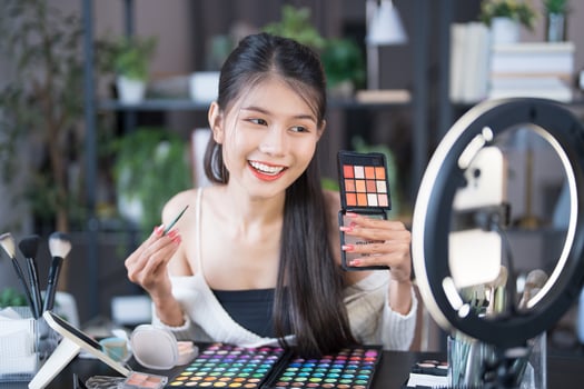 beauty blogger woman holding up a makeup palette photo