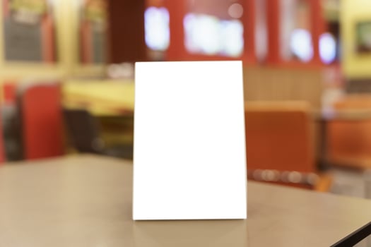 Mock up Menu frame standing on wood table in restaurant space for text. photo