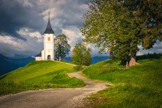 Winding rural road and Saint Primoz mountain church, Jamnik, Slovenia photo