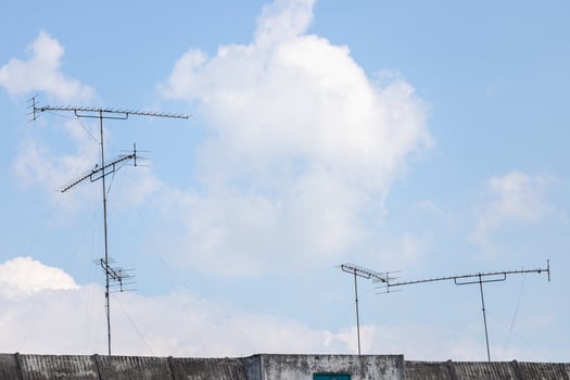 TV Antenna on the roof with blue sky and cloud background. photo