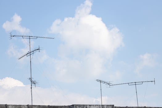 Television antenna on the roof with blue sky and white cloud. photo