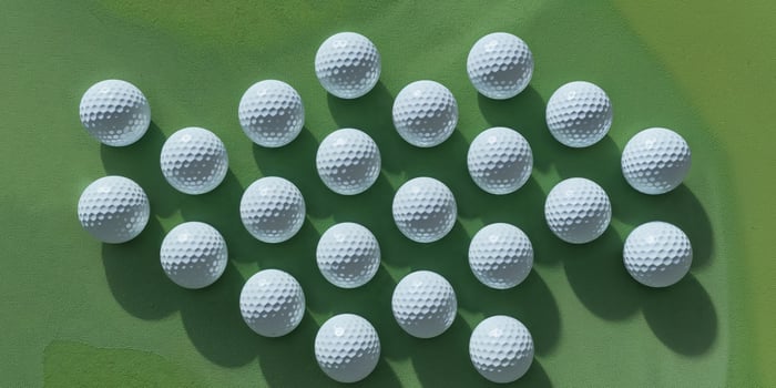 Neatly Arranged Set of Golf Balls Lined Up on a Lush Green Course. photo