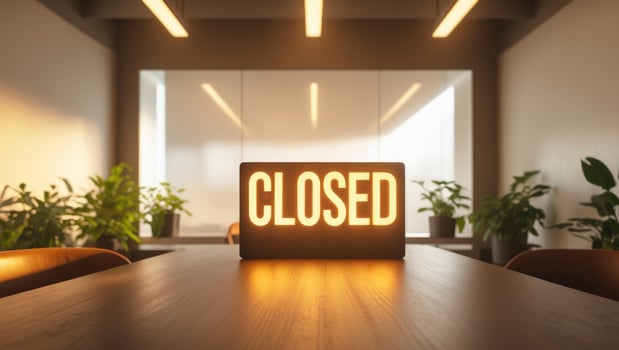 Bright Closed sign on a wooden table in an empty modern office with warm lighting and potted plants photo