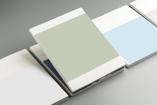 Various color swatches neatly arranged on a gray surface showcasing different shades and finishes in natural light photo