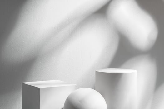 Abstract composition featuring three white geometric shapes in a minimalist interior setting photo