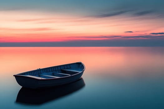 A serene Nordic sunset paints the sky with soft pink, orange, and blue hues while calm waters create perfect reflections. A small wooden boat adds elegance to this tranquil landscape photo