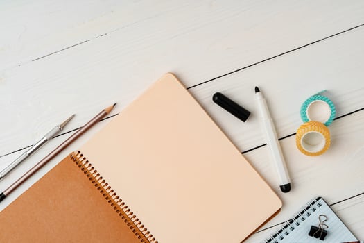 Creative workspace with open notebook, stationery, and decorative items on a wooden table photo