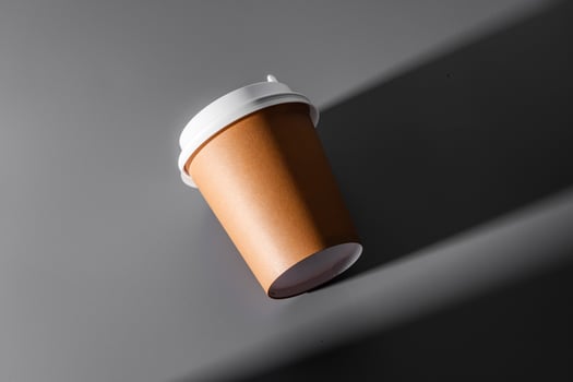 A minimalistic black coffee cup against a gray background photo