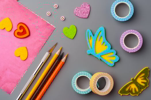 Crafting materials and tools arranged on a gray surface during a creative project photo