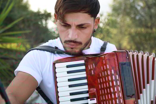 Man Studying Accordion And Watching On The Paper photo