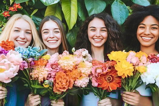 Four young women holding colorful bouquets of flowers and smiling photo