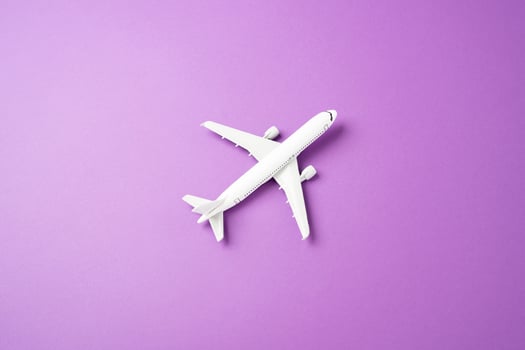 Passenger plane on a purple-pink background. Commercial flights Passenger transportation. Business tourism. photo