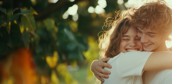 Joyful young couple embracing in nature with warm smiles and sunlit background. friendship day photo