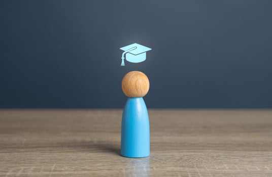 A man with a graduate cap symbol, the concept of getting an education and graduating from training. Reach graduation. Development paths and subsequent stages. Choose a new direction for learning. photo