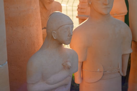 Intricate terracotta sculptures showcase artistry in a sunlit outdoor gallery photo