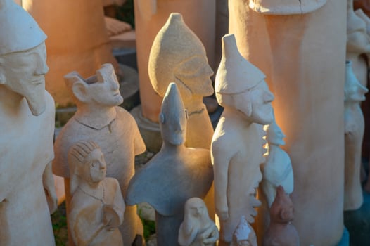 Artisans create unique clay sculptures at a vibrant outdoor market during sunset photo